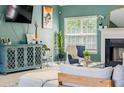 Cozy living room features a fireplace, a large window, and a well-decorated cabinet creating an inviting atmosphere at 4348 Tillage Path, Douglasville, GA 30135