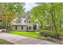Traditional home with gray roof nestled amongst mature trees on a sprawling lot at 5161 Hermitage Dr, Powder Springs, GA 30127