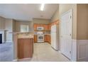 Well-lit kitchen with wooden cabinets, white appliances, and breakfast bar overlooking living area at 580 Camry Cir, Dallas, GA 30157