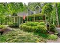 Inviting exterior with mature trees and landscaping highlighting a welcoming front porch at 2165 Robin Hood Trl, Cumming, GA 30040