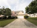 Inviting exterior view of a two-story home with a spacious driveway and lush green landscaping at 3292 Shady Valley Ct, Loganville, GA 30052