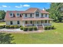 Inviting two-story home featuring a large front porch and well-manicured landscaping at 161 Honey Creek Rd, Mcdonough, GA 30252