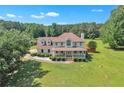 Charming two-story house with a covered porch and lush greenery in a serene setting at 161 Honey Creek Rd, Mcdonough, GA 30252
