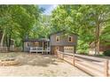 Charming two-story home with fenced yard and cozy fire pit area, surrounded by mature trees at 2642 Bridgehampton Sw Rd, Marietta, GA 30064