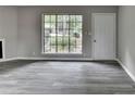 Living room with gray flooring, large window, and white door leading to the exterior of the home at 396 Independence Dr, Jonesboro, GA 30238