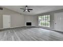 Open concept living room featuring a large window, vaulted ceiling, fireplace, and gray flooring at 396 Independence Dr, Jonesboro, GA 30238