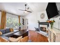 Cozy living room features a fireplace, ceiling fan, and a comfortable seating area with large windows at 6195 Queensdale Dr, Douglasville, GA 30135