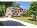 Two-story brick home with attached two car garage and a well-manicured lawn at 2470 Anderson Estates Ct, Marietta, GA 30064