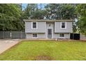 Inviting home featuring a lush green lawn and a secure, gated driveway at 2100 Scarbrough Rd, Stone Mountain, GA 30088