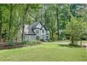 Two-story home surrounded by lush trees and landscaped lawn at 3250 Cobbs Farm Nw Trl, Marietta, GA 30064