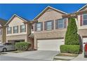 Charming brick townhome featuring a two-car garage and manicured landscaping in a well-maintained community at 328 Oaktown Ct, Lawrenceville, GA 30044