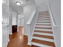 Staircase featuring hardwood floors and white trim creates an inviting transition between levels at 328 Oaktown Ct, Lawrenceville, GA 30044