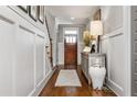 Inviting foyer featuring hardwood floors, white wainscoting, stairs, and a charming accent table at 2603 Apple Valley Ne Rd, Brookhaven, GA 30319