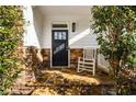 Charming front porch with stone flooring, accent wall, and a rocking chair at 2603 Apple Valley Ne Rd, Brookhaven, GA 30319