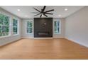 Modern living room with fireplace and large windows, filled with natural light, highlighting the hardwood floors at 553 Somersby Dr, Dallas, GA 30157