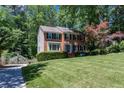 Two-story brick home boasts a well-manicured lawn, mature landscaping, and a driveway basketball hoop at 2122 Rockland Ct, Marietta, GA 30062