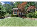 Traditional brick home with a lush front lawn, mature trees, and a basketball hoop on the driveway at 2122 Rockland Ct, Marietta, GA 30062