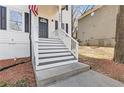 Front entrance with black door, white railings, and manicured landscaping at 2453 Paul Nw Ave, Atlanta, GA 30318