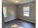 Inviting bedroom with warm lighting, hardwood floors, and sun-filled windows overlooking the street at 633 Tom Read Dr, Marietta, GA 30062