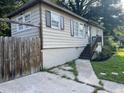 An exterior side view of a single-story home with a sidewalk, driveway, and wooden fence at 633 Tom Read Dr, Marietta, GA 30062