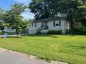 Cozy single-story home with a well-manicured lawn and lush trees in the front yard at 633 Tom Read Dr, Marietta, GA 30062