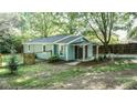 Home featuring a covered front porch, fenced yard, landscaping, and mature trees at 4443 Toonigh Nw Rd, Acworth, GA 30101