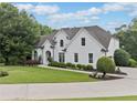 Stately white home with a well-manicured lawn and mature trees, offering a serene setting at 590 Arthur Rd, Canton, GA 30115