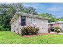 Charming single-story home featuring a well-kept lawn, dark door and lush landscaping at 933 Capitol View Nw Ave, Atlanta, GA 30318