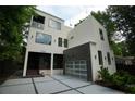 Modern two-story home featuring sleek lines, a glass garage door, and a contemporary design at 1099 Vista Ne Trl, Atlanta, GA 30324
