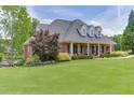 Brick home with a manicured lawn and mature trees offers a picturesque and serene setting at 2623 Lindsey Grace Ln, Buford, GA 30519