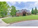 Expansive front yard and driveway leading to a brick home exuding classic elegance and inviting outdoor space at 2623 Lindsey Grace Ln, Buford, GA 30519