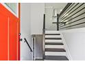 The entryway has black and white stairs, a modern railing and an orange front door at 1349 Heather Cir, Riverdale, GA 30296