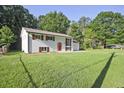 Exterior of a single-story home with painted white brick, brown shutters, red door and a well-manicured lawn at 1349 Heather Cir, Riverdale, GA 30296