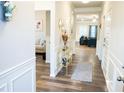 Bright hallway with wood floors, white wainscoting, and views into the living room at 1431 Beckett Dr, Hampton, GA 30228