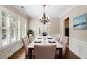 Elegant dining room with hardwood floors, plantation shutters, and a classic chandelier at 255 Kendemere Pointe, Roswell, GA 30075