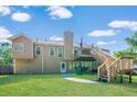 The back exterior of this home features a wooden deck, staircase and a well maintained lawn at 435 Flowering Trl, Grayson, GA 30017