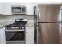 Well-equipped kitchen with stainless steel gas range, microwave, refrigerator, and granite countertops at 2091 Moon Drive Sw, Conyers, GA 30094