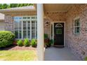 Inviting entryway with brick facade, decorative shutters, and manicured landscaping at 530 Mount Park Dr, Powder Springs, GA 30127