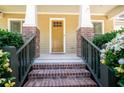 Inviting front porch with brick pillars, wood railings, and a charming wood front door at 6418 Crown Forest Ct, Mableton, GA 30126