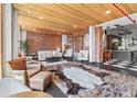 Bright living room with exposed brick, wood ceilings, oversized windows, and access to the adjacent kitchen at 87 Peachtree Sw St # 209, Atlanta, GA 30303