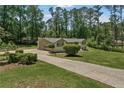 Sprawling ranch-style home showcasing an attached garage and a long driveway surrounded by mature trees at 145 Devilla Trce, Fayetteville, GA 30214