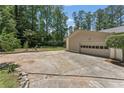 Spacious concrete driveway leading to a two-car garage, providing ample parking and storage at 145 Devilla Trce, Fayetteville, GA 30214