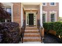 Brick home entryway featuring a black front door, brick steps, and wrought iron railings at 2484 Mossy Branch Dr, Snellville, GA 30078
