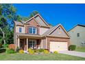 Charming two-story home with brick and siding, a well-manicured lawn, and an attached two-car garage at 3537 Edenridge Ct, Buford, GA 30519