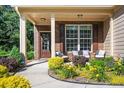 Inviting covered front porch with seating area, beautiful landscaping and brick accents at 3537 Edenridge Ct, Buford, GA 30519