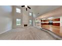 Open-concept living room with a fireplace, soaring ceilings, and seamless flow into the adjacent kitchen at 514 Jadetree Ln, Atlanta, GA 30349