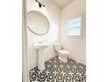 Stylish half bathroom with patterned tile floor, pedestal sink, and modern lighting fixture at 4305 Huron Dr, Cumming, GA 30028