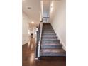 A carpeted staircase with dark wood floors, trim and banister leads to the upper level at 4305 Huron Dr, Cumming, GA 30028