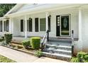 Inviting covered front porch with white columns and black accents at 3210 Roseheath Ln, Lithonia, GA 30038