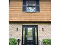 Close up of front door with sidelights flanked by brick and trimmed with black shutters and planters at 3352 Northbrook Dr, Atlanta, GA 30340